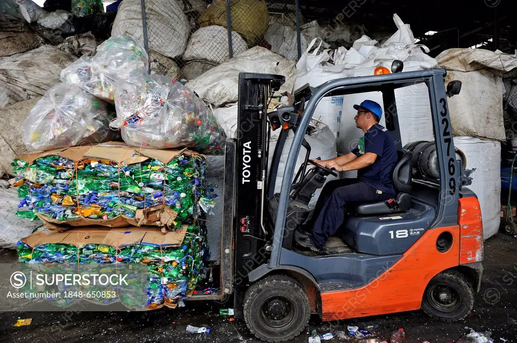 Forklift transporting compressed and packaged plastic bottles at a recycling plant for the export to China, San José, Costa Rica, Latin America, Centr...