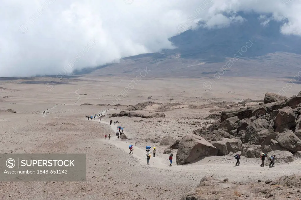 Trekking, mountain climbing, view from the Kibo Hut over many carriers and trekkers on the trail of the Kibo Saddle, Kilimanjaro, Marangu Route, Tanza...