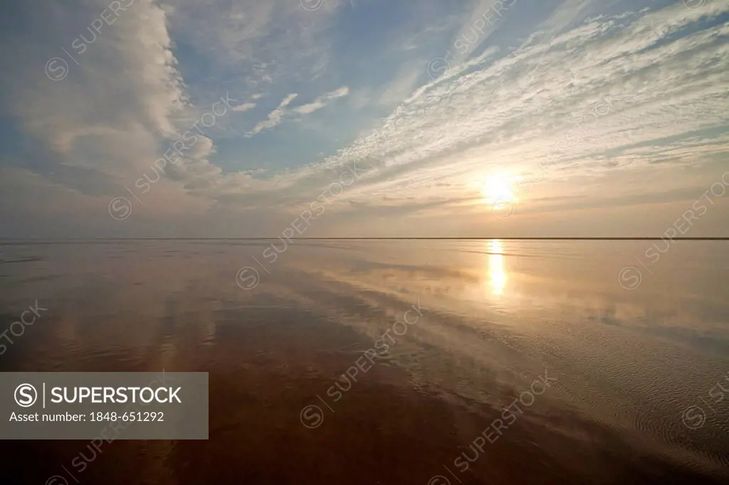 Clouds are being reflected in the shallow waters of the North Sea at low tide, Schleswig-Holstein Wadden Sea National Park, a UNESCO World Heritage, W...