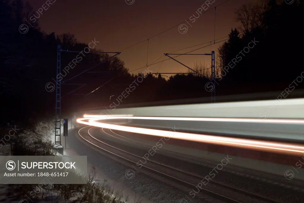 Light trace of a train in winter at night, Beimerstetten, Baden-Wuerttemberg, Germany, Europe