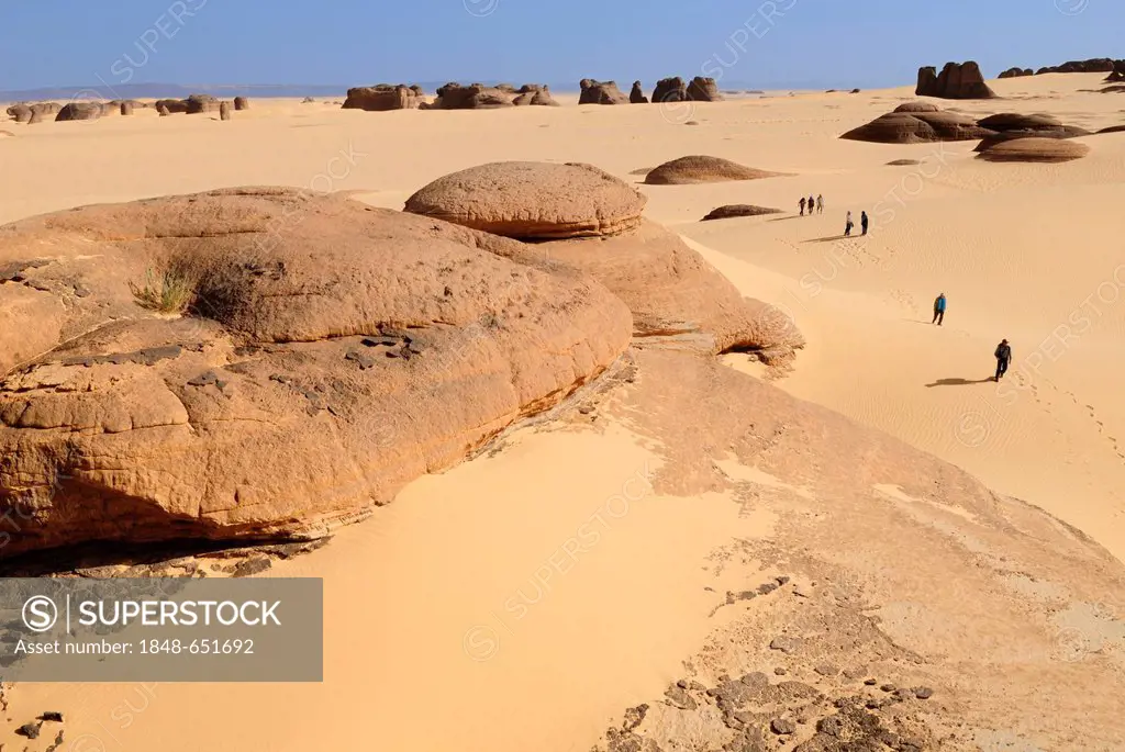 Group of tourists, hikers in the sandstone rock formation of Tin Akachaker, Tassili du Hoggar, Wilaya Tamanrasset, Algeria, Sahara desert, North Afric...