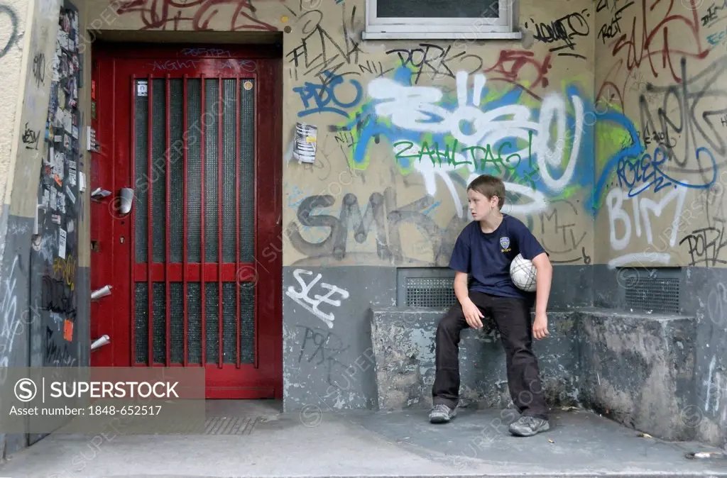 Weary boy, 10 years, sitting in a doorway, Cologne, North Rhine-Westphalia, Germany, Europe