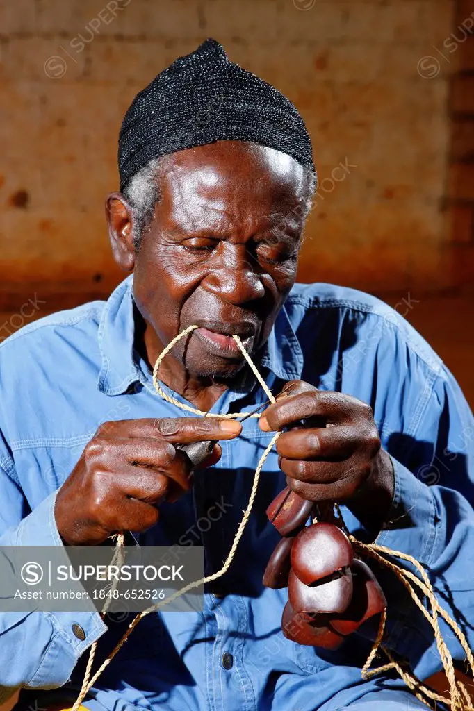 Man making traditional foot and hand rattles, Juju Rattles from Uyot, Bafut, Cameroon, Africa