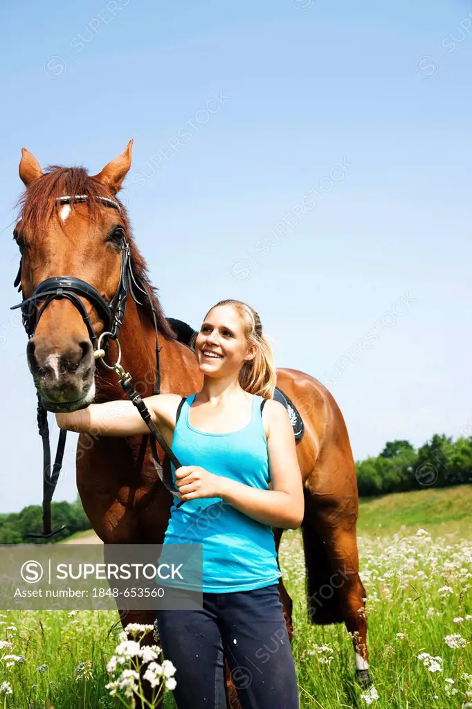 Girl patting her horse affectionately on the neck