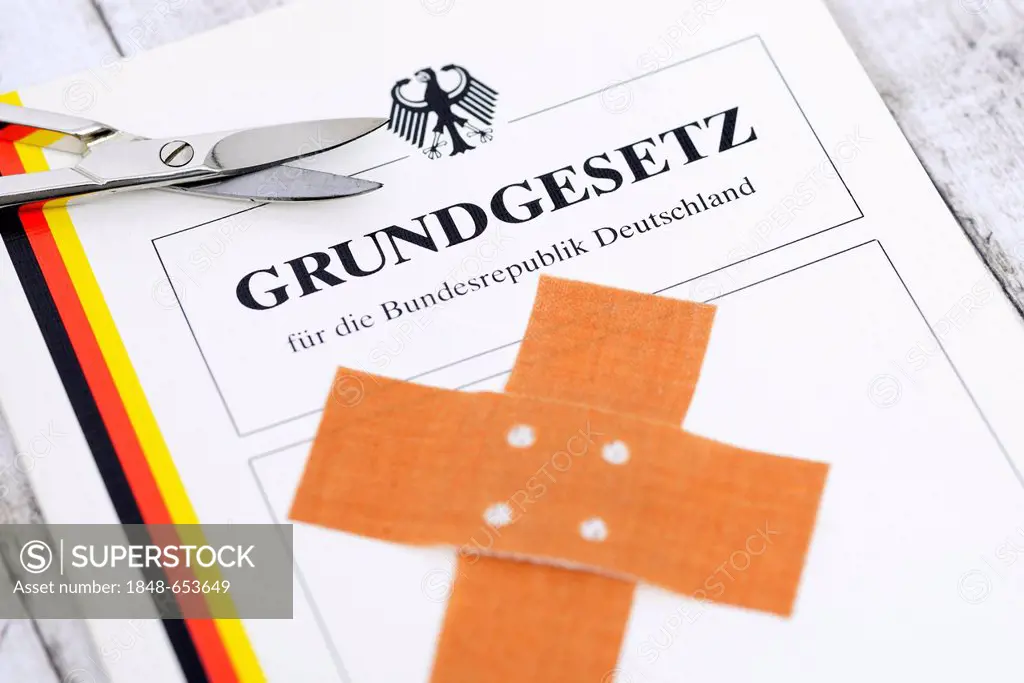 German Basic Law covered with a band-aid and scissors, symbolic image for circumcision and the German law