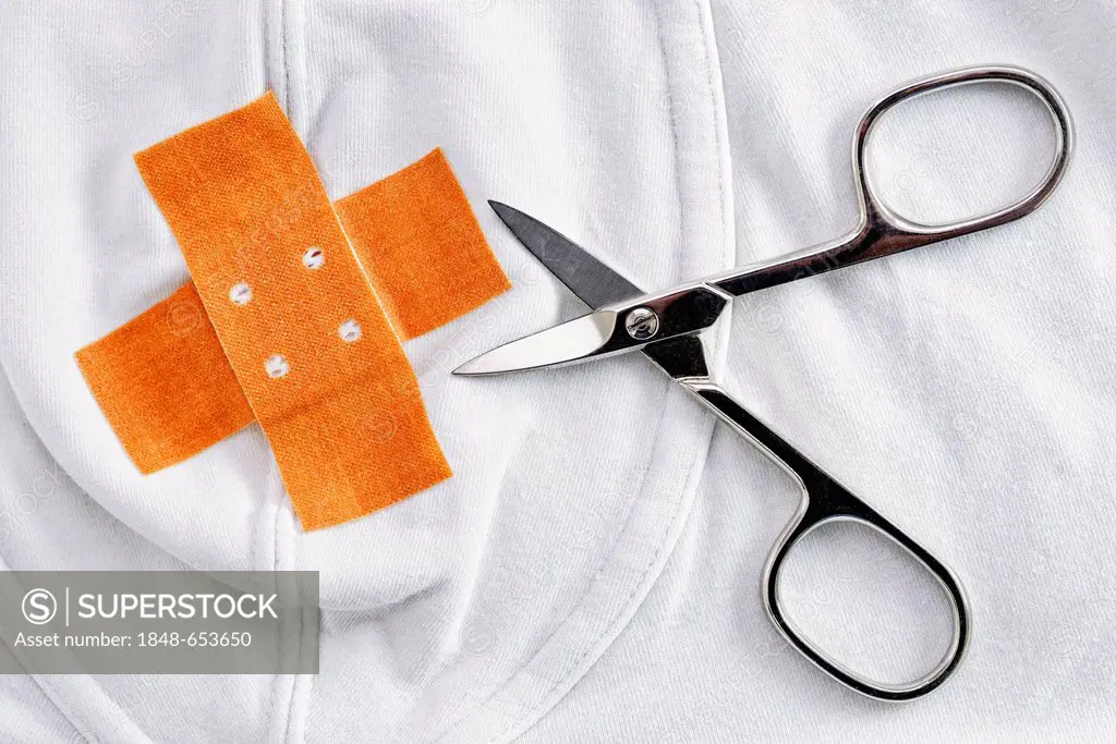 Underpants with a band-aid and scissors, symbolic image for circumcision
