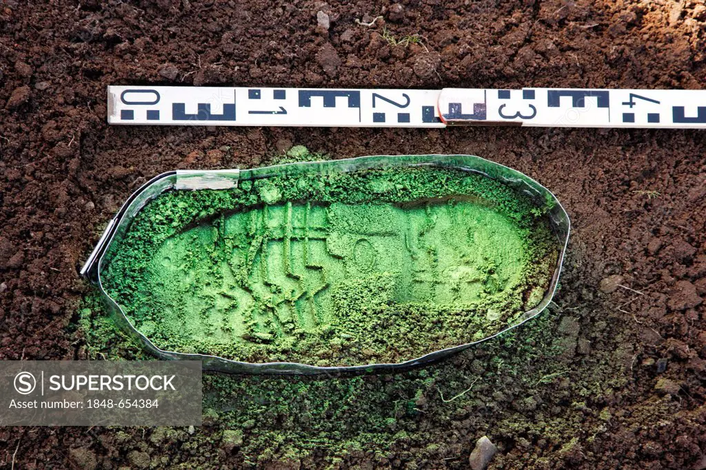 Criminal investigation department, police, shoe print at a crime scene, print made visible with green spray paint and taking of a plaster mould