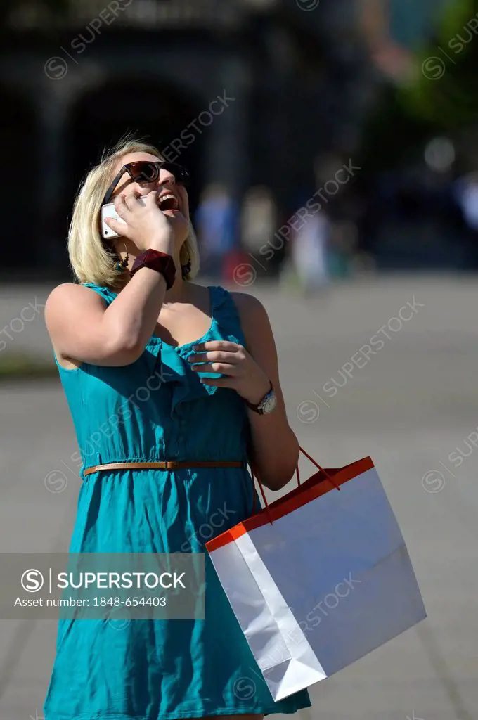 Young woman speaking on a mobile phone, on a shopping tour, Koenigsstrasse street, Stuttgart, Baden-Wuerttemberg, Germany, Europe, PublicGround