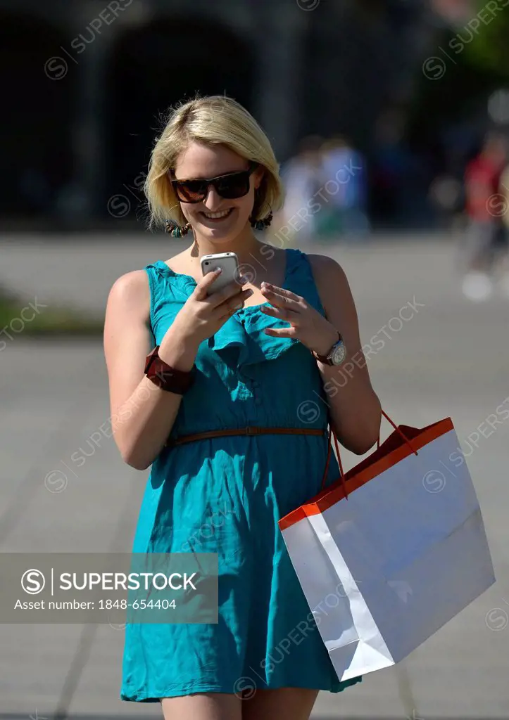 Young woman with a mobile phone, on a shopping tour, Koenigsstrasse street, Stuttgart, Baden-Wuerttemberg, Germany, Europe, PublicGround