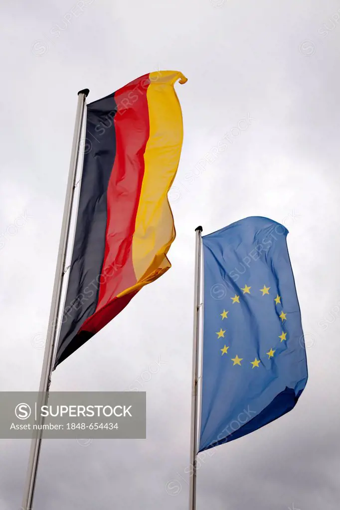 Dark clouds behind the flags of Germany and Europe