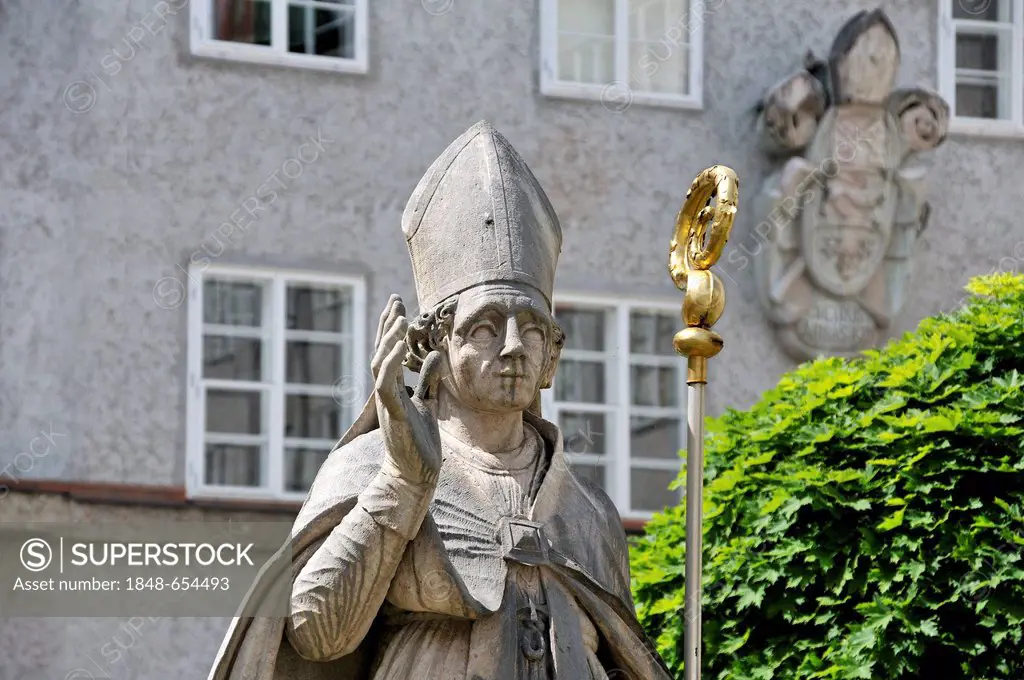 Statue of Saint Benedikt in the courtyard of Kolleg St Benedikt monastery, a coat of arms of the church at the back, St. Peter District 8-9, Salzburg,...