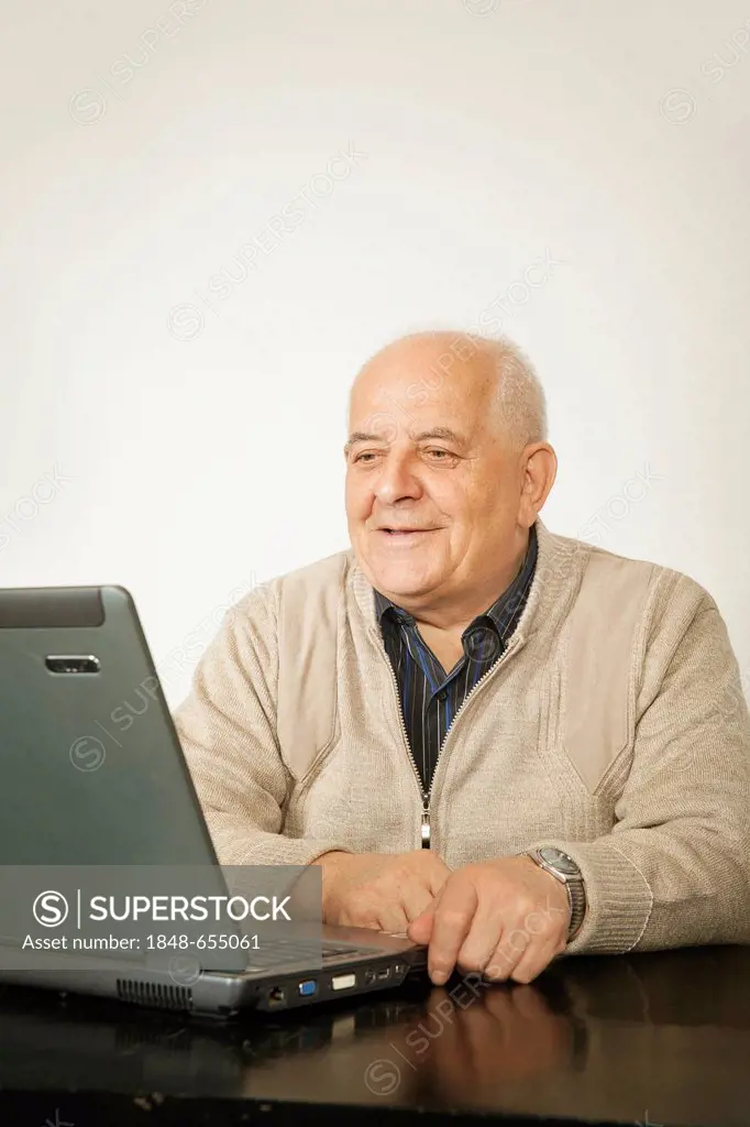 Old man sitting in front of a laptop