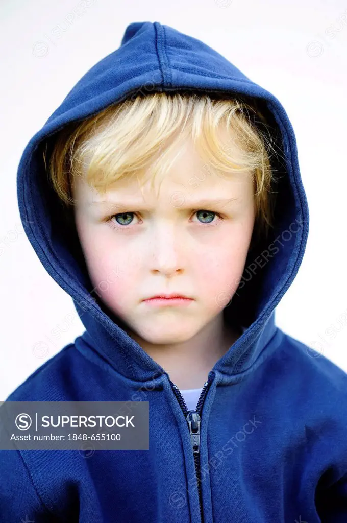Grim faced 5-year-old boy wearing a hoodie jacket, portrait