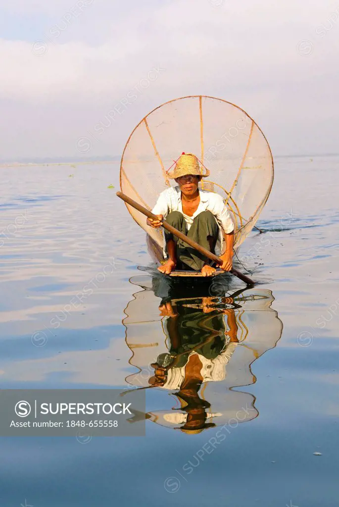 Fisherman with traditional bow net sitting in his canoe, Inle Lake, Myanmar, Burma, Southeast Asia, Asia