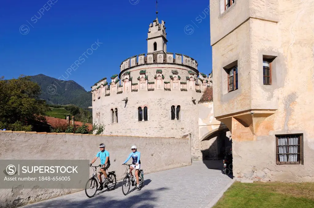 Couple riding electric bicycles, Neustift monastery, Brixen, province of Bolzano-Bozen, Italy, Europe