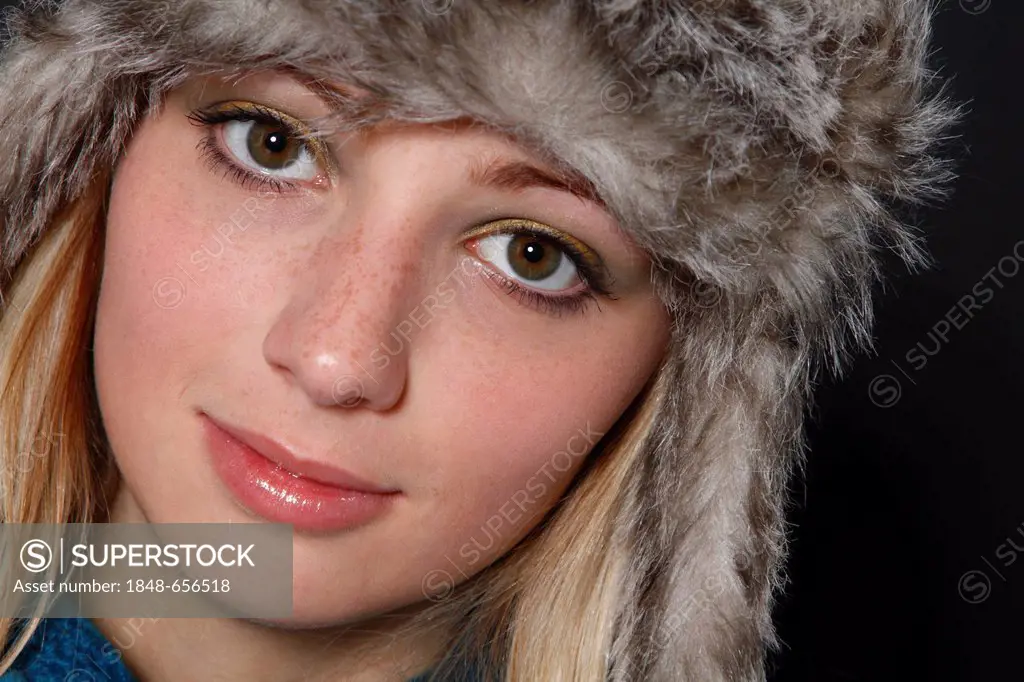 Young, blonde woman with a fur cap, 19 years, portrait