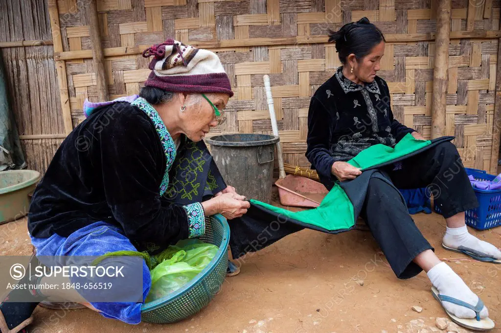 Elderly, traditionally dressed women from the Black Hmong hill tribe, ethnic minority from East Asia, doing needlework, embroidery, Northern Thailand,...