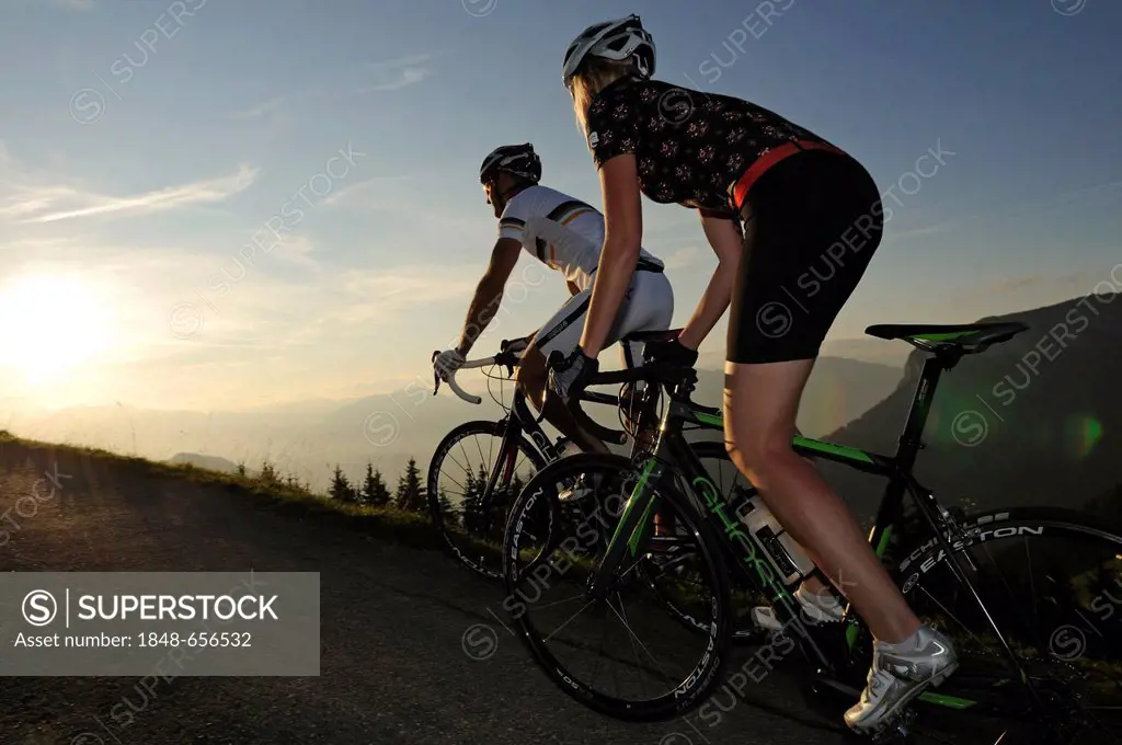 Couple riding racing bikes, Kraftalm alp, Mt Hohe Salve, Kitzbuehel Alps, Tyrol, Austria, Europe