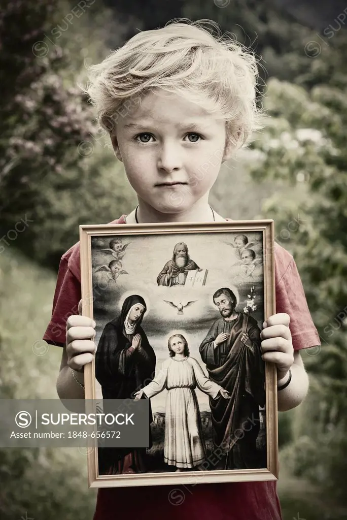 Boy holding a Christian image of saints, with Jesus, Mary and Joseph, pneuma