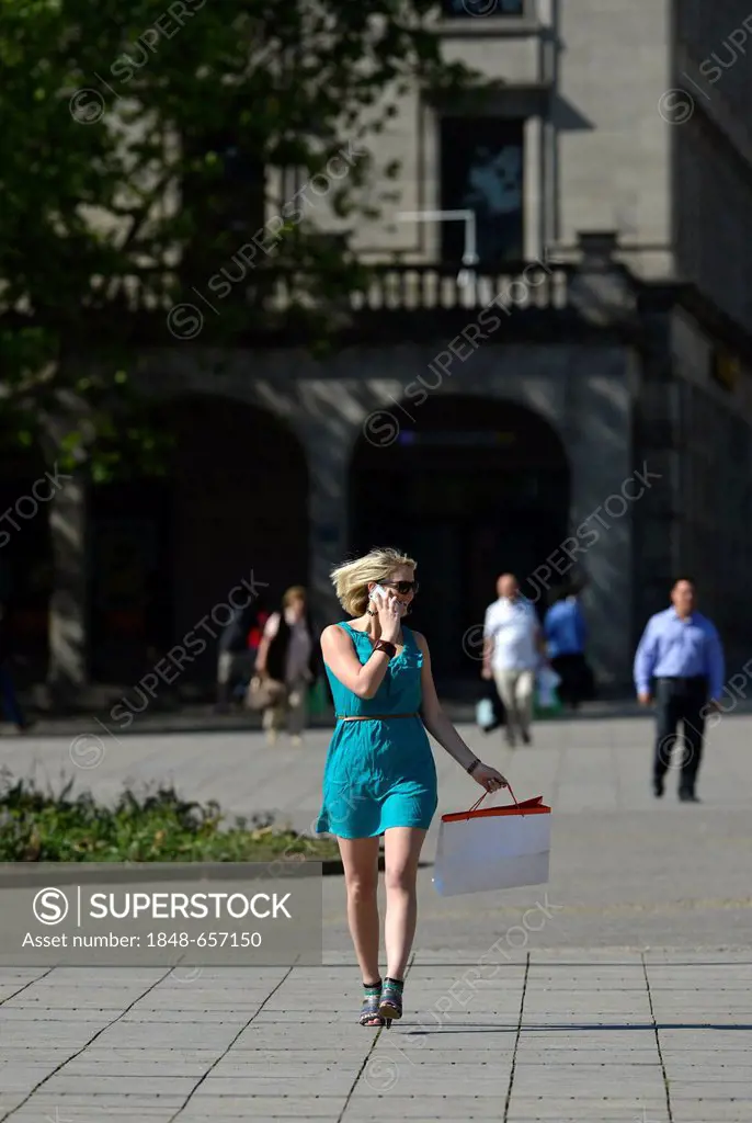 Young woman speaking on a mobile phone, on a shopping tour, Koenigsstrasse street, Stuttgart, Baden-Wuerttemberg, Germany, Europe, PublicGround
