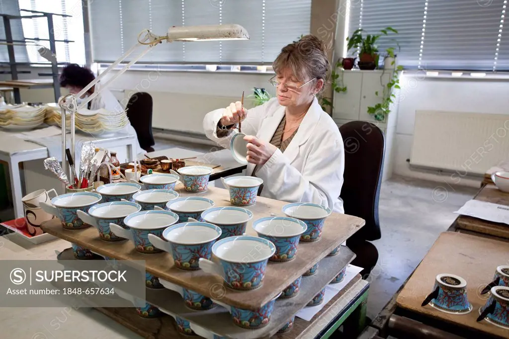 Employee painting a Versace teacup at the porcelain manufacturer Rosenthal GmbH, Speichersdorf, Bavaria, Germany, Europe