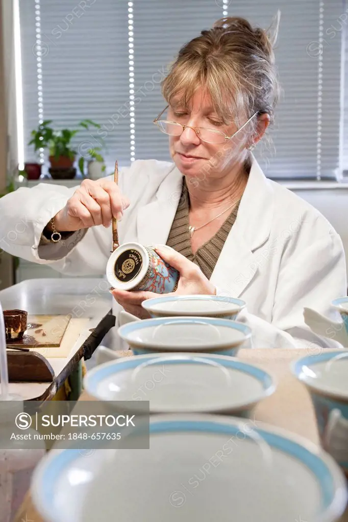 Employee painting a Versace teacup at the porcelain manufacturer Rosenthal GmbH, Speichersdorf, Bavaria, Germany, Europe