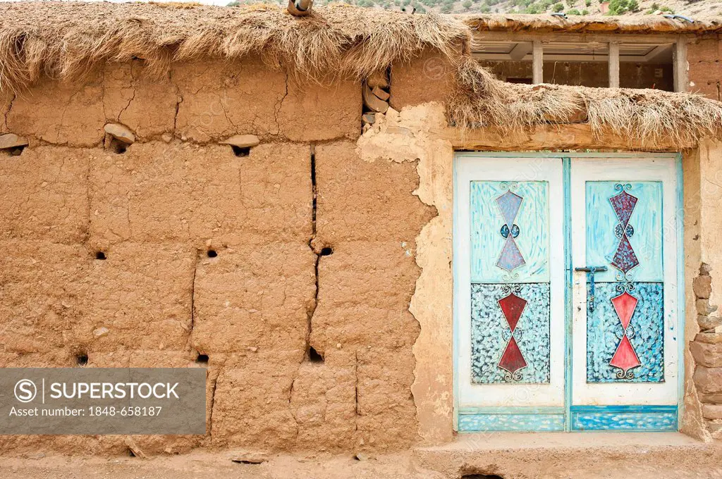 Facade made of adobe bricks, typical ornamental metal door, painted, Ait Bouguemez Valley, High Atlas Mountains, Morocco, Africa