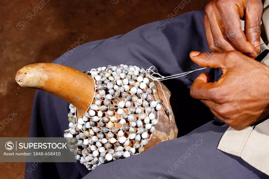 Man producing a traditional hand rattle, Juju Rattles from Klebassen, Bafut, Cameroon, Africa