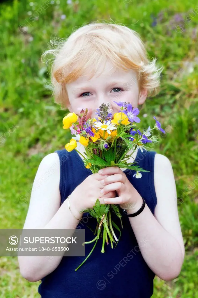 Little boy holding a bouquet of field flowers