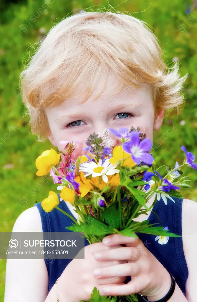 Little boy holding a bouquet of field flowers