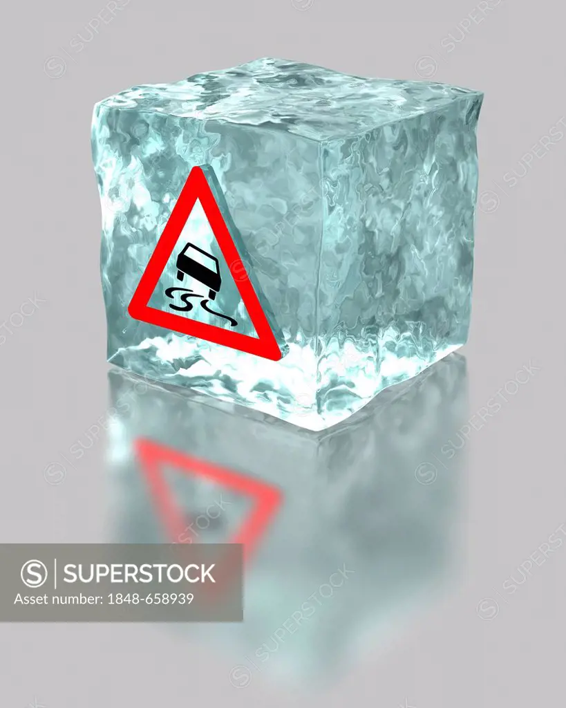 Block of ice with a traffic warning sign for slippery roads, symbolic image for the mandatory use of winter tyres