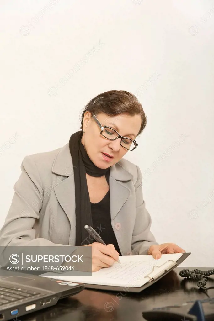 Business woman working with a laptop and a clipboard