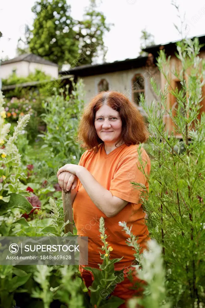 Woman leaning on gardening tools