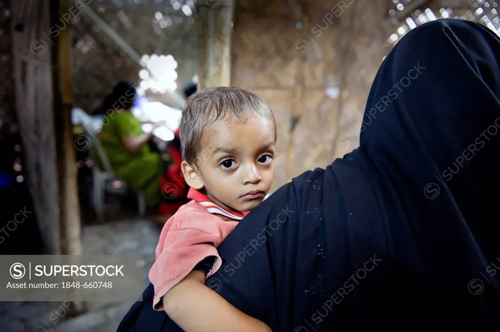Woman carrying a child in her arms, clinic set up in a bamboo hut by the aid organisation Aerzte fuer die Dritte Welt, German for Doctors for the Thir...