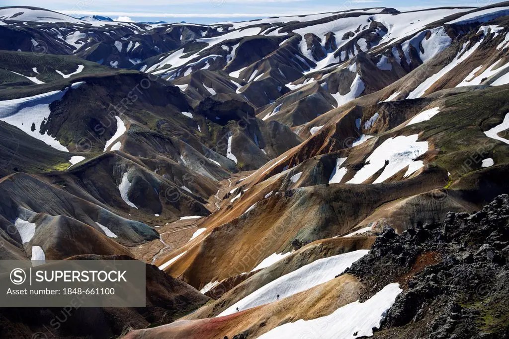 Hikers on a trail, view from the Brennisteinsalda volcano to the snow-capped rhyolite mountains, Landmannalaugar, Fjallabak Nature Reserve, Highlands,...