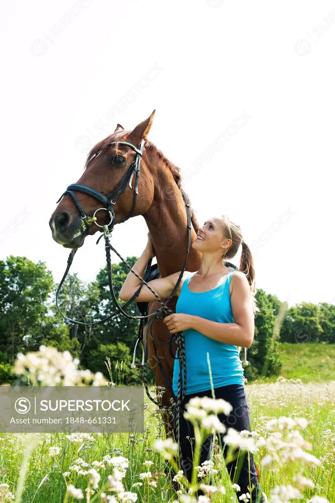 Girl patting her horse affectionately on the neck