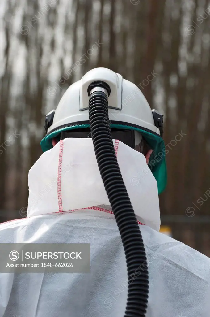 Worker wearing a respiratory protection filter device at a toxic waste dump, Germany, Europe
