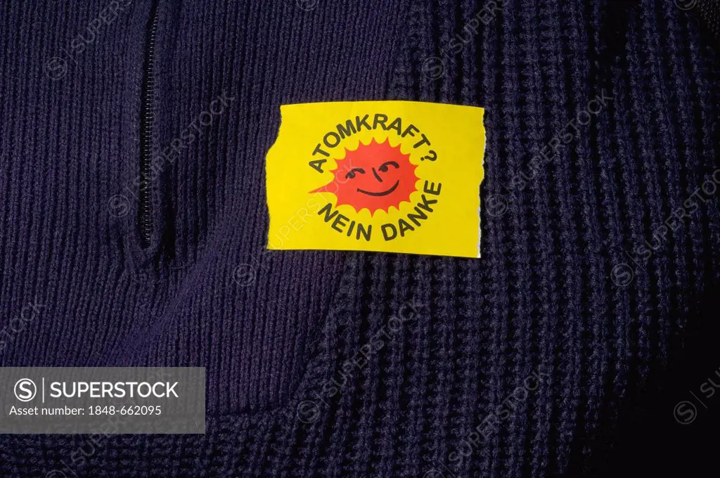 Yellow sticker Atomkraft nein danke, German for nuclear power, no thanks, on a blue knitted sweater