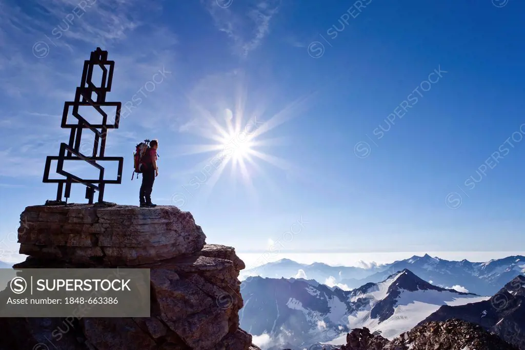 Mountaineer standing next to the summit cross on Hoher Angulus mountain, Ortler Alps, province of Bolzano-Bozen, Italy, Europe