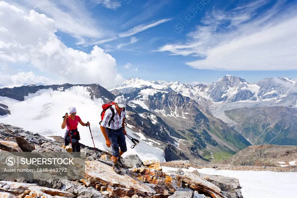 Hikers climbing Mt Vertainspitze or Cima Vertana, Ortler mountain range, Mt Koenigsspitze and Mt Zebru at back, South Tyrol, Italy, Europe