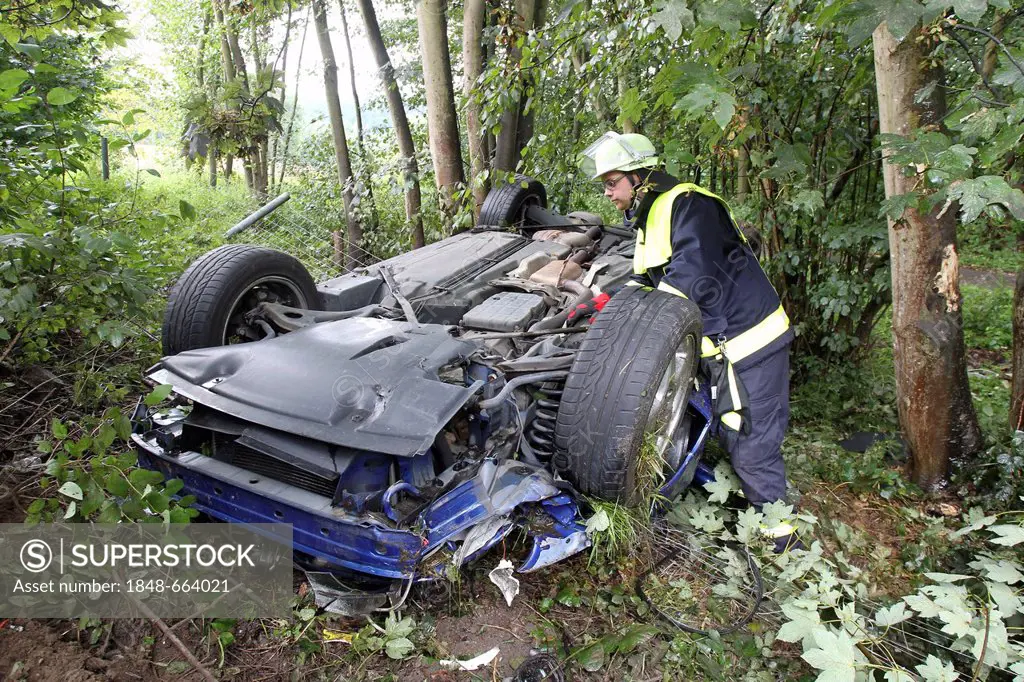 Firefighter attending a car wreck after an accident on the A48 Autobahn, motorway, Hoehr-Grenzhausen, Rhineland-Palatinate, Germany, Europe
