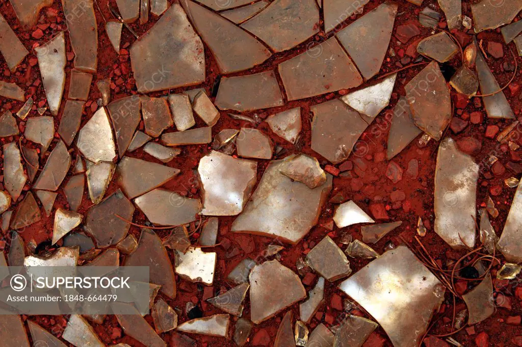 Broken glass in red soil, Pilbara, Western Australia, Australia