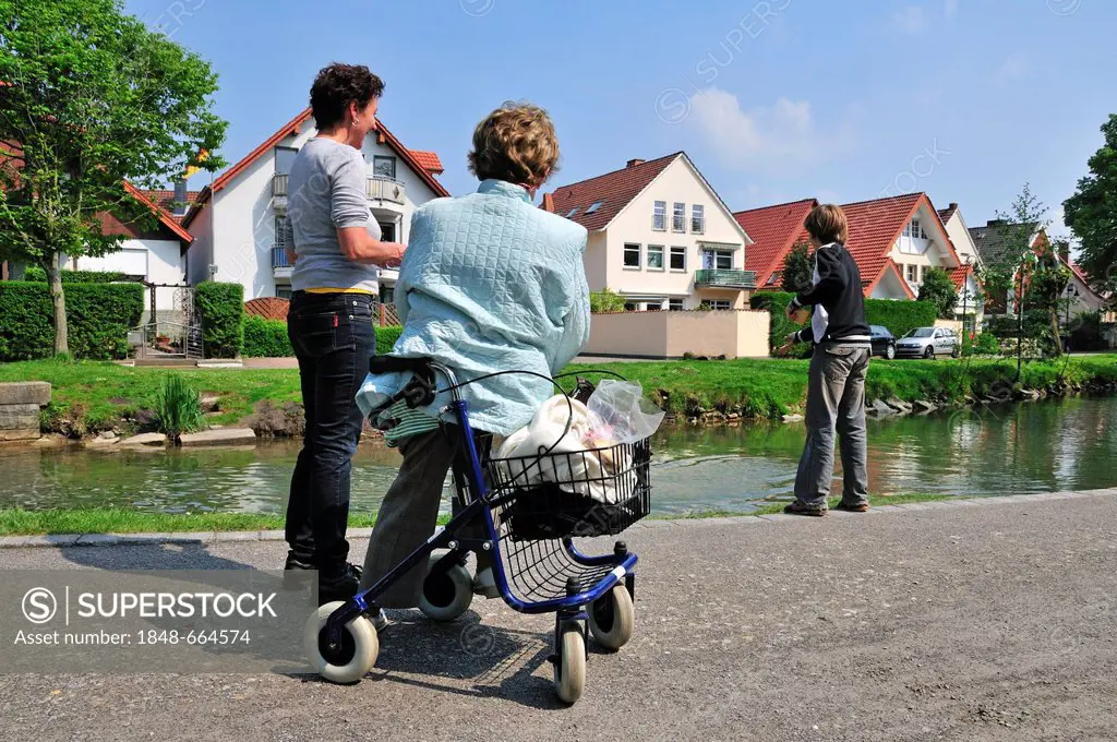 Three generations, grandmother, mother and son feeding ducks, Germany, Europe