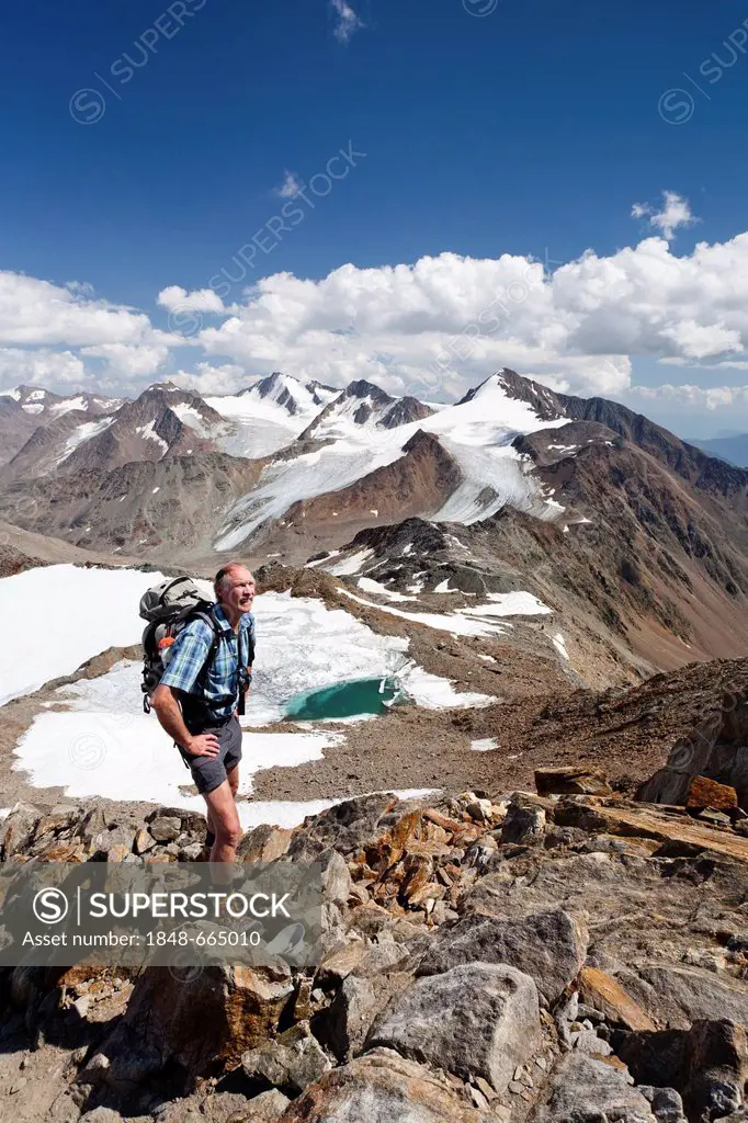 Hiker during the ascent to Finailspitz Mountain in Schnalstal valley through the Tisental valley, Similaun Mountain and Hintere Schwaerze Mountain at ...