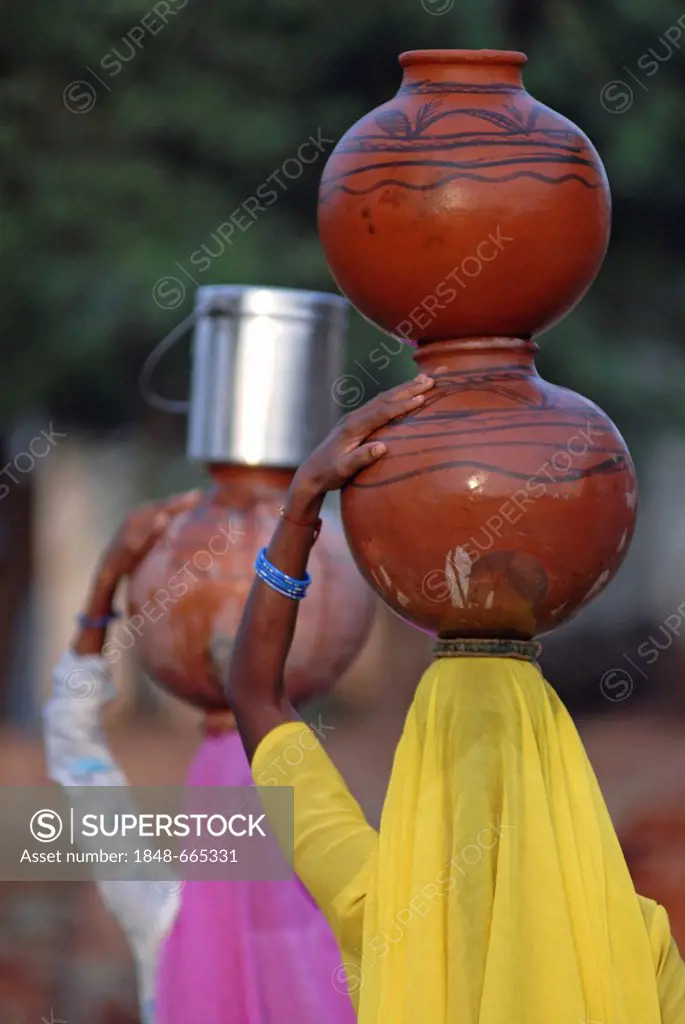 Women carrying water-filled clay pots on their heads, Neemrana, Rajasthan, North India, India, Asia