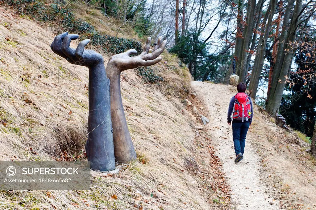 Hiker hiking along the sculpture route of the artist Sieglinde Tatz Borgogno below Duerer's Route and Buchholz, Laag, Unterland, Alto Adige, Italy, Eu...