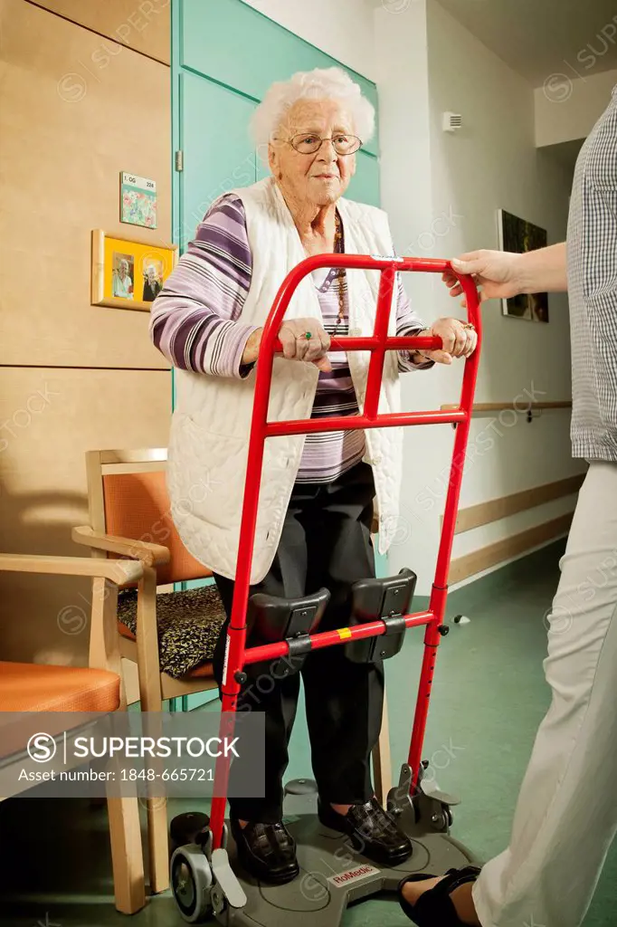 Elderly woman with an aid for standing up, nursing home, rehabilitation
