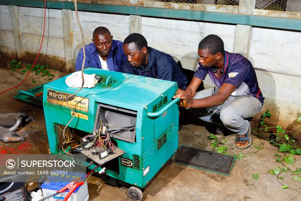 Mechanics repairing an emergency power generator, hospital, Manyemen, Cameroon, Africa