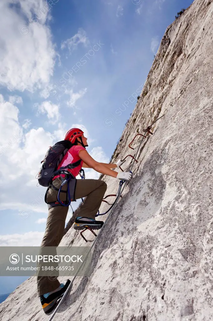 Mountaineer climbing on the Che Guevara fixed rope route on Monte Casale mountain, Sarca valley, Lake Garda region, province of Trento, Italy, Europe