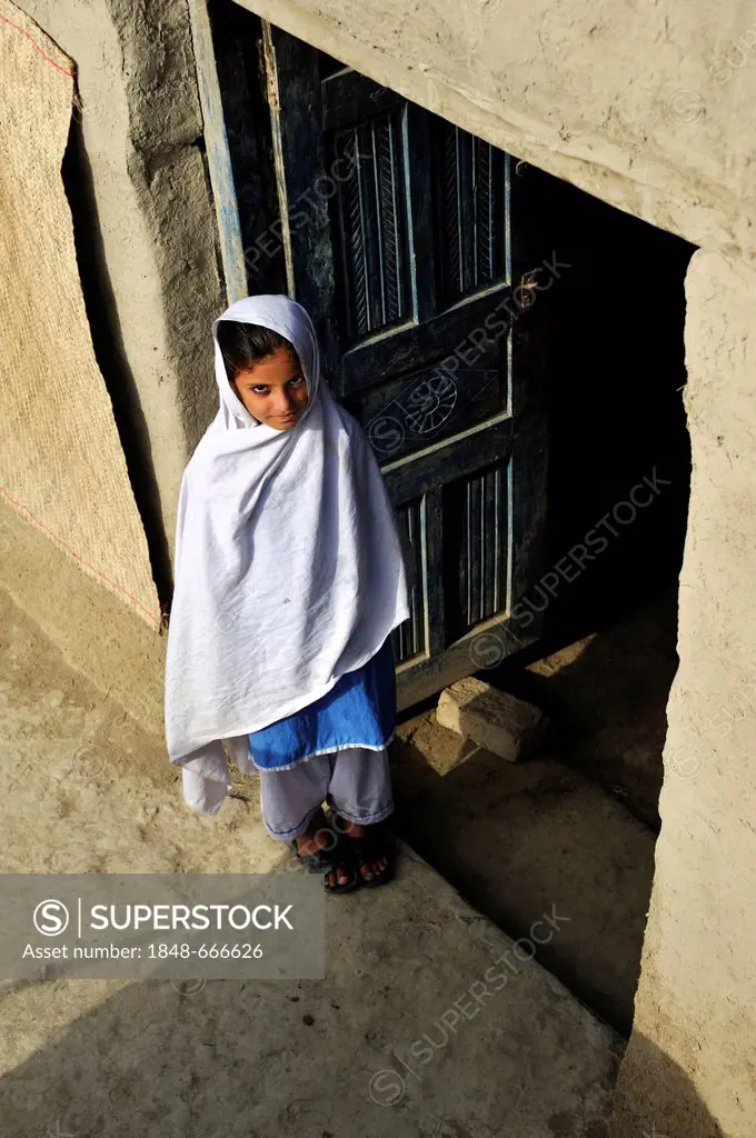 Girl in the doorway of her house made of mud, village of Lashari Wala, Punjab, Pakistan, Asia